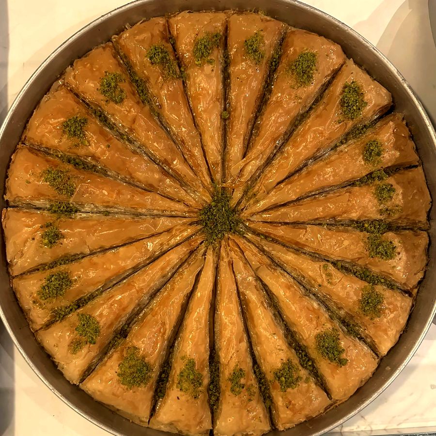 Plateau rond de baklava au pistache, coupé en pointes disposées en soleil